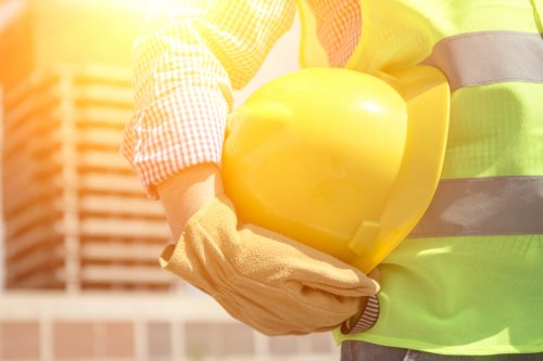 a construction worker holding a safety helmet