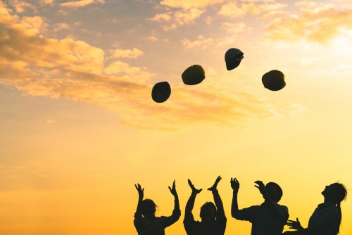 construction workers throwing their safety helmets up in the air